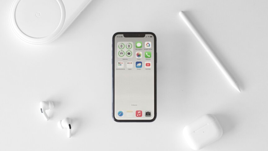 白い机の上に置かれたスマートフォンとイヤホン